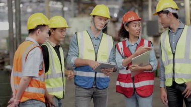 Bir grup çeşitlilik fabrikası çalışanı proje başarıya ulaştığında ayakta duruyor ve yerel depoda birlikte kutluyorlar, Asyalı, beyaz, beyaz ve Asyalı insanlar ağır makine fabrikasında çalışıyorlar..