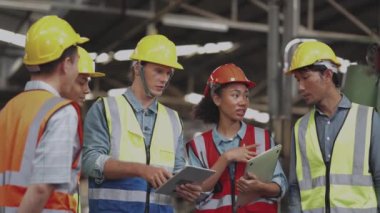 Bir grup çeşitlilik fabrikası çalışanı proje başarıya ulaştığında ayakta duruyor ve yerel depoda birlikte kutluyorlar, Asyalı, beyaz, beyaz ve Asyalı insanlar ağır makine fabrikasında çalışıyorlar..