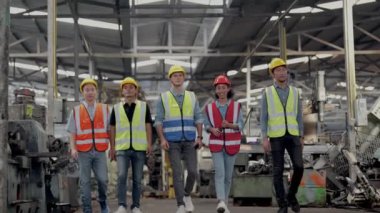 Bir grup çeşitlilik fabrikası çalışanı proje başarıya ulaştığında ayakta duruyor ve yerel depoda birlikte kutluyorlar, Asyalı, beyaz, beyaz ve Asyalı insanlar ağır makine fabrikasında çalışıyorlar..