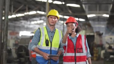 Bir grup çeşitlilik fabrikası çalışanı proje başarıya ulaştığında ayakta duruyor ve yerel depoda birlikte kutluyorlar, Asyalı, beyaz, beyaz ve Asyalı insanlar ağır makine fabrikasında çalışıyorlar..