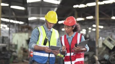 Bir grup çeşitlilik fabrikası çalışanı proje başarıya ulaştığında ayakta duruyor ve yerel depoda birlikte kutluyorlar, Asyalı, beyaz, beyaz ve Asyalı insanlar ağır makine fabrikasında çalışıyorlar..