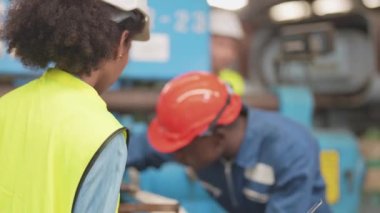 Fabrika Profesyonel Afrikalı ve Asyalı işçi ve makinede yönetici müfettişi ve fabrika çevresindeki teftişi tartışıyorlar. Operasyondan önce kalite ve yetkilendirme testleri için tamir edilen ekip mühendisleri.
