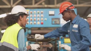 Fabrika Profesyonel Afrikalı ve Asyalı işçi ve makinede yönetici müfettişi ve fabrika çevresindeki teftişi tartışıyorlar. Operasyondan önce kalite ve yetkilendirme testleri için tamir edilen ekip mühendisleri.