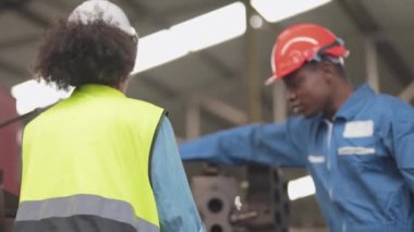 Fabrika Profesyonel Afrikalı ve Asyalı işçi ve makinede yönetici müfettişi ve fabrika çevresindeki teftişi tartışıyorlar. Operasyondan önce kalite ve yetkilendirme testleri için tamir edilen ekip mühendisleri.