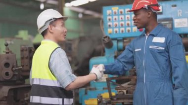 Fabrika Profesyonel Afrikalı ve Asyalı işçi ve makinede yönetici müfettişi ve fabrika çevresindeki teftişi tartışıyorlar. Operasyondan önce kalite ve yetkilendirme testleri için tamir edilen ekip mühendisleri.