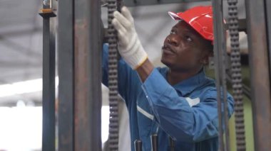 Fabrika Profesyonel Afrikalı ve Asyalı işçi ve makinede yönetici müfettişi ve fabrika çevresindeki teftişi tartışıyorlar. Operasyondan önce kalite ve yetkilendirme testleri için tamir edilen ekip mühendisleri.