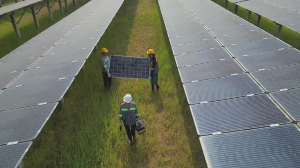 拥有太阳能电池板和在太阳能农场行走的工人的头像 工程师检查太阳能电池板的结构 无人机飞越太阳能电池板地面可再生绿色替代能源 — 图库视频影像
