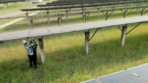 Inżynierowie Sprawdzają Panele Słoneczne Spacerują Farmie Słonecznej Lot Dronem Nad — Wideo stockowe