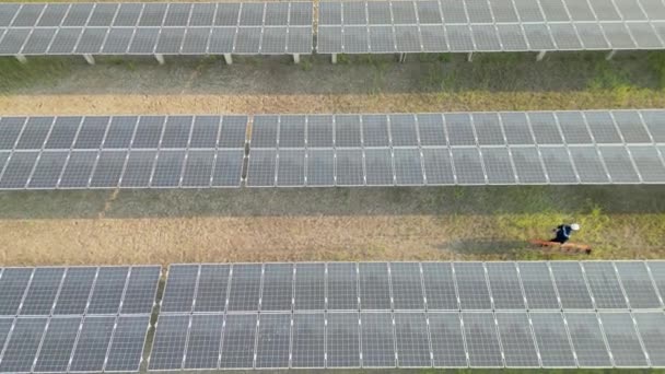 在太阳能农场步行查看太阳能电池板的工人的头像 无人机飞越太阳能电池板地面可再生绿色替代能源 — 图库视频影像