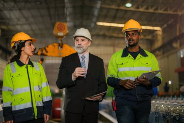 Mühendislerden oluşan bir ekip fabrikadaki ağır makineleri kontrol ediyor. Kıdemli patron mühendis kadın ve Afrikalı adamla birlikte denetleme yapıyor. Konsept Mühendisi Fabrikada güvenlik ile birlikte çalışır ve kontrol eder.