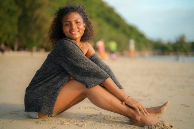 Afrikalı kadın sahilde oturuyor. Seksi Afrikalı kadın portresi tropikal doğayla yaz aylarında gezip dinleniyor..