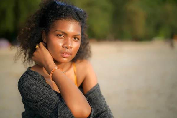 stock image African woman sitting on bench beach at tropical beach. Young traveler wearing yellow bikini and chilling out the beauty of the Nature. Wanderlust and travel concept. 