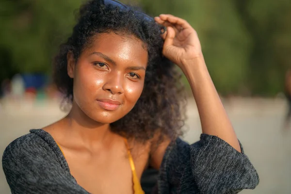 Stock image African woman sitting on bench beach at tropical beach. Young traveler wearing yellow bikini and chilling out the beauty of the Nature. Wanderlust and travel concept. 