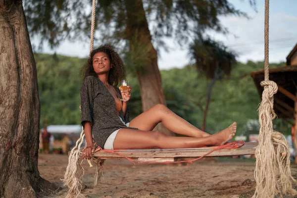 Afrikanerin Trinkt Cocktailsaft Wenn Sie Tropischen Strand Auf Einer Schaukel — Stockfoto