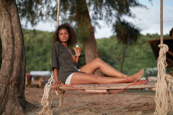 Afrikanerin Trinkt Cocktailsaft Wenn Sie Tropischen Strand Auf Einer Schaukel — Stockfoto