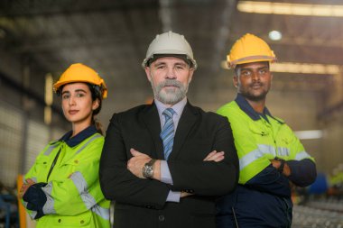 Portre mühendisi kıdemli patron takım fabrikasında çalışan Afrikalı kadın ve erkekten emin duruyor. İşçi, sanayi fabrikasındaki ağır makinede çalışıyor. Makine teçhizatı ile bitki teknolojisi.