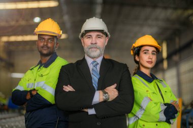 Portre mühendisi kıdemli patron takım fabrikasında çalışan Afrikalı kadın ve erkekten emin duruyor. İşçi, sanayi fabrikasındaki ağır makinede çalışıyor. Makine teçhizatı ile bitki teknolojisi.