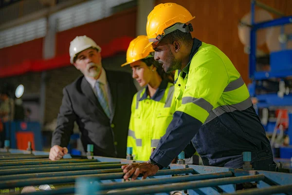 スタッフエンジニア女性とアフリカ人男性とシニアボスマネージャー検査 工場建物の建設構造をチェックチーム 鉄屋根構造と機械設置の倉庫 — ストック写真