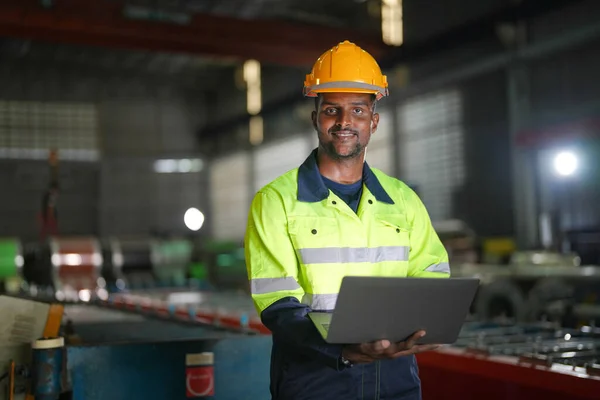 엔지니어 아프리카 사람은 노트북으로 자신있게 있습니다 노동자는 공장의 중장비에서 일한다 — 스톡 사진