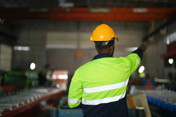 在非洲男人的背后手拉手管理着工业工厂 集中在工作场所的工人的肖像 智能工业运作及维修的概念 — 图库照片