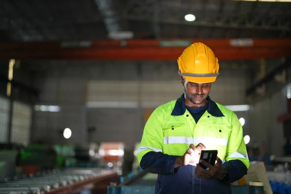 在工厂里拿着智能手机的非洲男工 集中在工作场所的工人的肖像 智能工业运作及维修的概念 — 图库照片