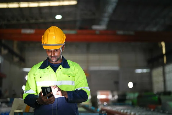 在工厂里拿着智能手机的非洲男工 集中在工作场所的工人的肖像 智能工业运作及维修的概念 — 图库照片