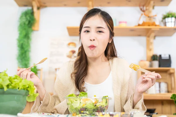 stock image Smiling woman eating fresh healthy salad vegetables. woman sitting at pantry in a beautiful interior kitchen. The clean diet food from local products and ingredients Market fresh.