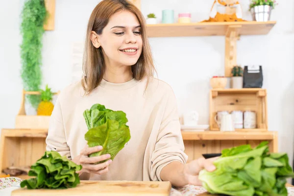 stock image Young woman preparing healthy food with salad vegetables. woman sitting at pantry in a beautiful interior kitchen. The clean diet food from local products and ingredients Market fresh.