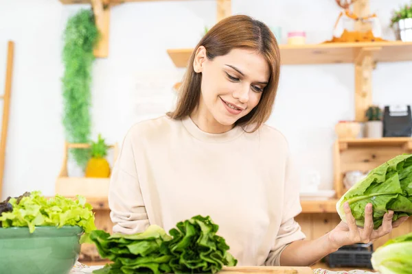 stock image Young woman preparing healthy food with salad vegetables. woman sitting at pantry in a beautiful interior kitchen. The clean diet food from local products and ingredients Market fresh.