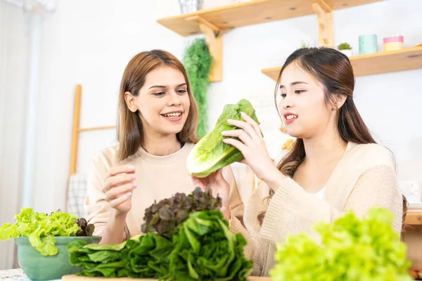 stock image Smiling women preparing fresh healthy salad vegetables. woman sitting at pantry in a beautiful interior kitchen. The clean diet food from local products and ingredients Market fresh.