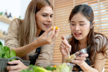 Gülümseyen kadınlar taze sağlıklı salata sebzeleri hazırlıyorlar. Güzel bir iç mutfakta kilerde oturan bir kadın. Yerel ürünlerden ve malzemelerden alınan temiz diyet gıdaları taze pazardır..