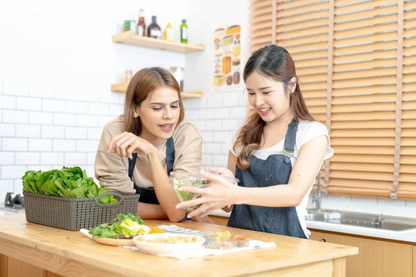 stock image Smiling women preparing fresh healthy salad vegetables. woman sitting at pantry in a beautiful interior kitchen. The clean diet food from local products and ingredients Market fresh.