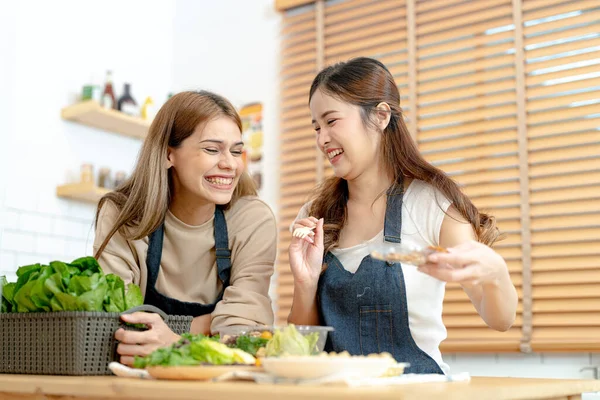 Gülümseyen kadınlar taze sağlıklı salata sebzeleri hazırlıyorlar. Güzel bir iç mutfakta kilerde oturan bir kadın. Yerel ürünlerden ve malzemelerden alınan temiz diyet gıdaları taze pazardır..