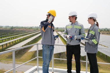 Mühendisler çatıdaki güneş panelini kontrol etmek için toplanıyor. Super Energy Corporation Specialists tarafından işletilen bir enerji depolama sistemine sahip güneş çiftliği Photovoltaic cells modülü için toplandı.