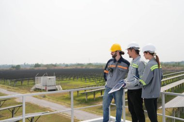 Mühendisler çatıdaki güneş panelini kontrol etmek için toplanıyor. Super Energy Corporation Specialists tarafından işletilen bir enerji depolama sistemine sahip güneş çiftliği Photovoltaic cells modülü için toplandı.