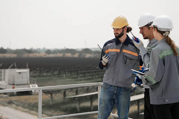 Engineers Meeting to check solar panel at roof top. solar farm with an energy storage system operated by Super Energy Corporation Specialists Gathered for Outdoor testing Photovoltaic cells module.