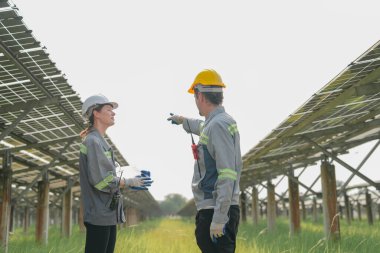 Güneş çiftliğindeki fotovoltaik hücre modülünün enerji depolama sistemi ile test edilmesi için toplanan uzmanlar.