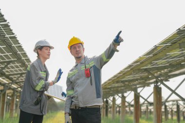 Güneş çiftliğindeki fotovoltaik hücre modülünün enerji depolama sistemi ile test edilmesi için toplanan uzmanlar.