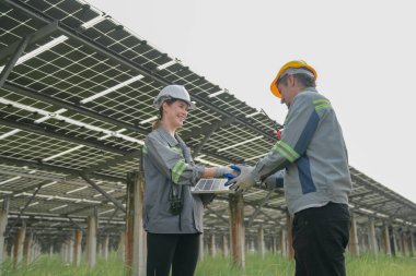 Güneş çiftliğindeki fotovoltaik hücre modülünün enerji depolama sistemi ile test edilmesi için toplanan uzmanlar.