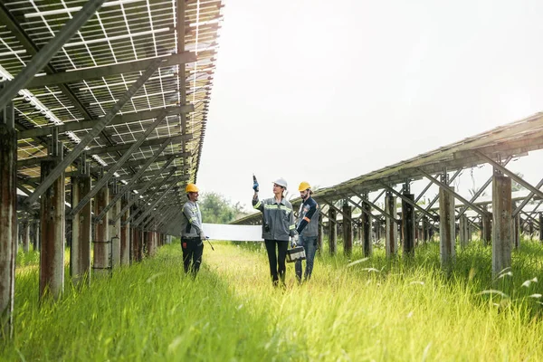 一组持有太阳能电池板或光伏电池的工程师正在行走和检查太阳能电池板或光伏电池的建造 — 图库照片