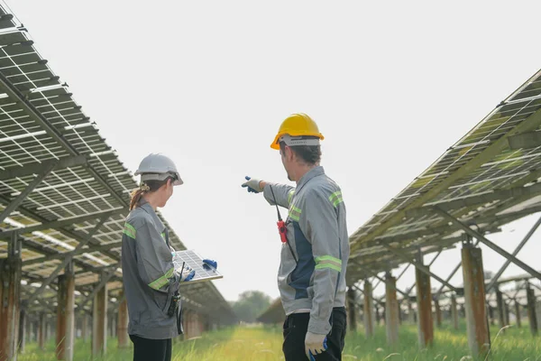 专家们聚集在有能量存储系统的太阳能农场进行室外测试光伏电池模块 — 图库照片