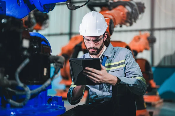 엔지니어가 스마트 태블릿으로 기계를 조사하고 있습니다 노동자는 무거운 일합니다 공장에 — 스톡 사진