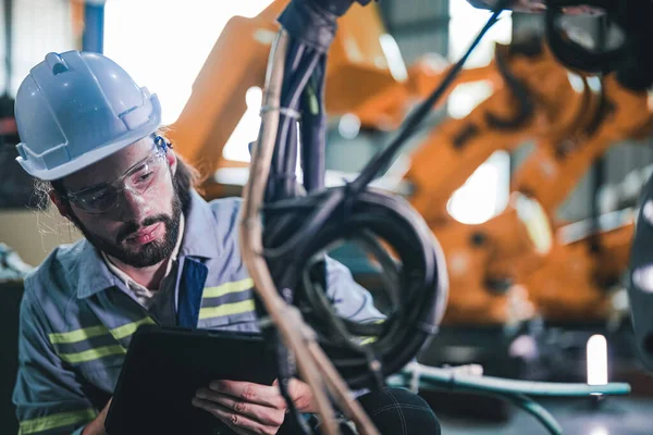 기사가 기계로 케이블 전기를 조사하고 공장에서 중장비 로일하는 노동자 — 스톡 사진
