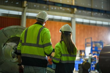 Profesyonel mühendisler depo fabrikasına girip kontrol ediyorlar. Yönetici, iç denetim için teftiş raporunu tartışıyor. Üretim için kalite güvencesi. Konsept Mühendisi.