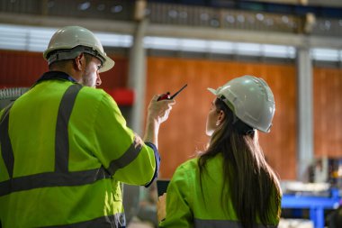 Profesyonel mühendisler depo fabrikasına girip kontrol ediyorlar. Yönetici, iç denetim için teftiş raporunu tartışıyor. Üretim için kalite güvencesi. Konsept Mühendisi.