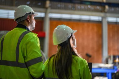 Profesyonel mühendisler depo fabrikasına girip kontrol ediyorlar. Yönetici, iç denetim için teftiş raporunu tartışıyor. Üretim için kalite güvencesi. Konsept Mühendisi.