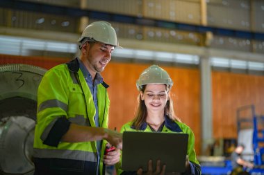 Profesyonel mühendisler depo fabrikasına girip kontrol ediyorlar. Yönetici, iç denetim için teftiş raporunu tartışıyor. Üretim için kalite güvencesi. Konsept Mühendisi.