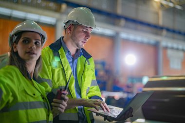 Profesyonel mühendisler depo fabrikasına girip kontrol ediyorlar. Yönetici, iç denetim için teftiş raporunu tartışıyor. Üretim için kalite güvencesi. Konsept Mühendisi.