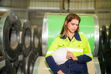 Fabrika işçisi çelik rulo üzerinde oturuyor ve stres altında fabrika atölyesinde başarısız oluyor..