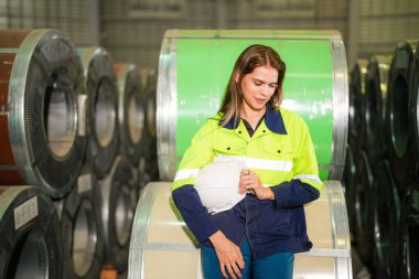 Fabrika işçisi çelik rulo üzerinde oturuyor ve stres altında fabrika atölyesinde başarısız oluyor..